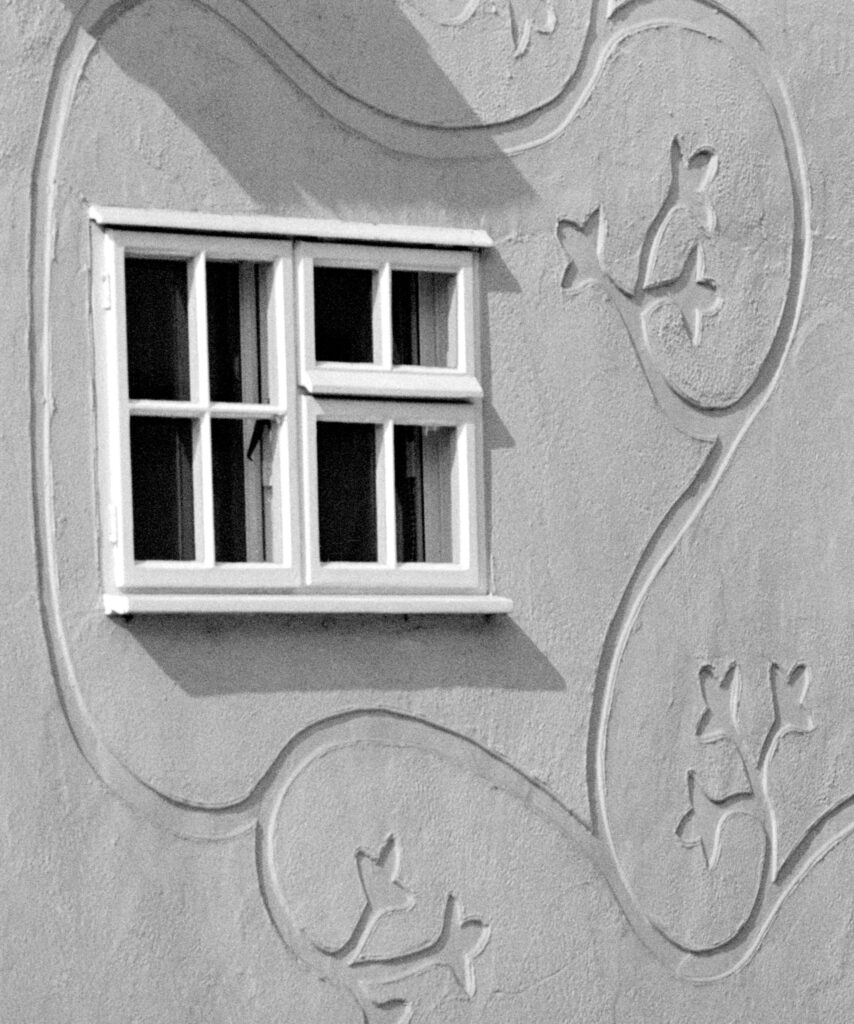 A window with swirling lines called pargeting around it.